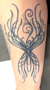 abstract phoenix tattoo belonging to Paula Wilson, acupuncturist, herbalist and hypnotherapist